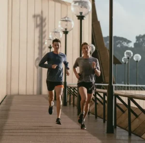 One young girl and one young boy jogging outdoors, highlighting the importance of staying active for long-term health, including prostate wellness.
